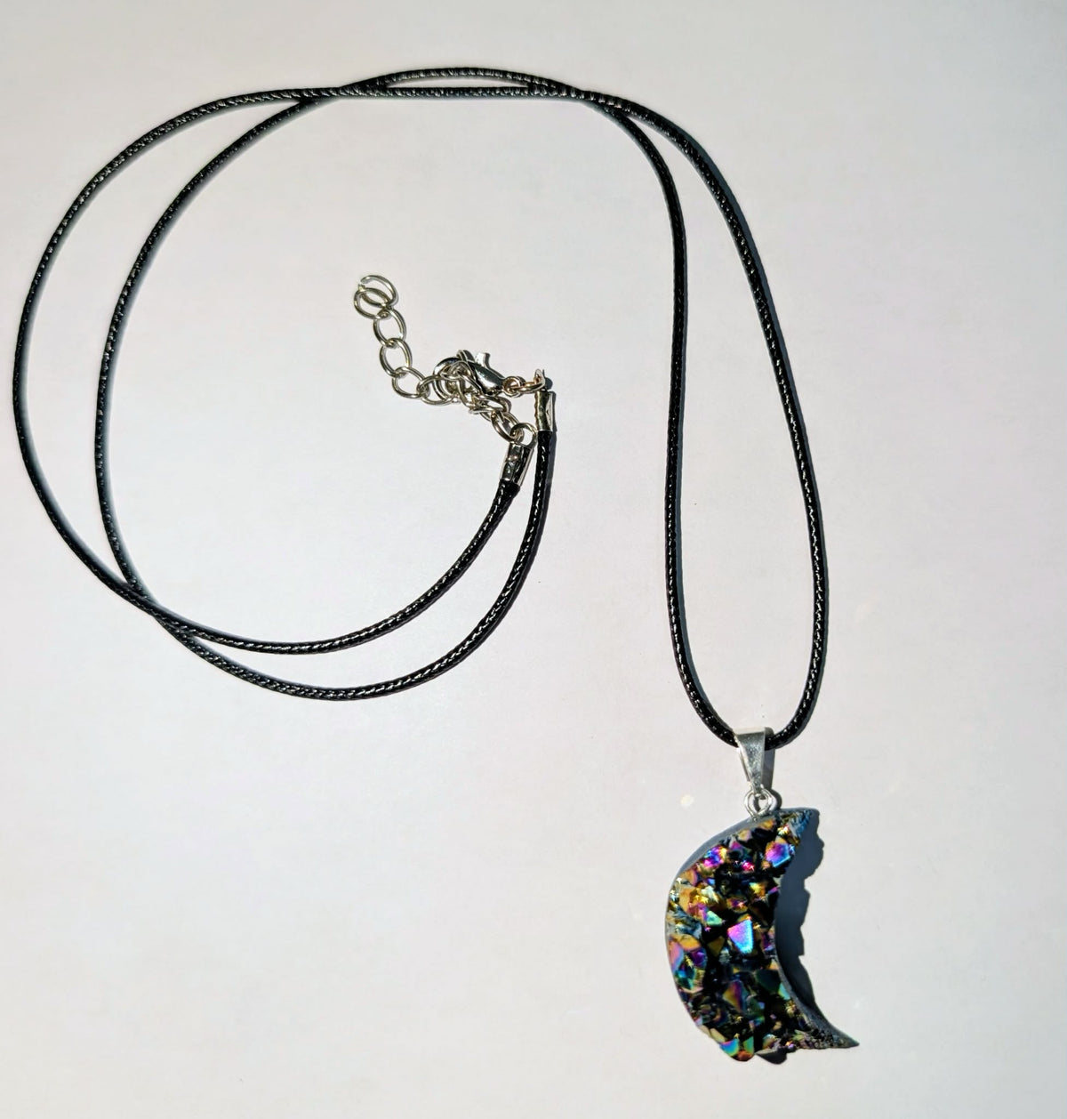 Silver-plated crescent moon pendant featuring sparkling amethyst druzy with rainbow accents, celestial-inspired crystal jewelry.