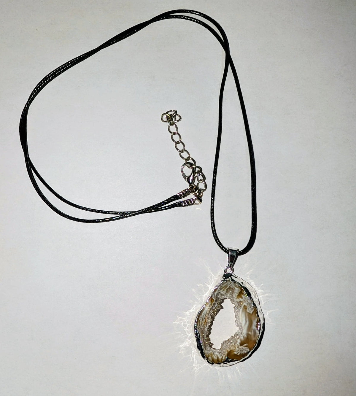 Occo slice pendant in a silver-plated setting featuring a natural stone slice with unique organic patterns.