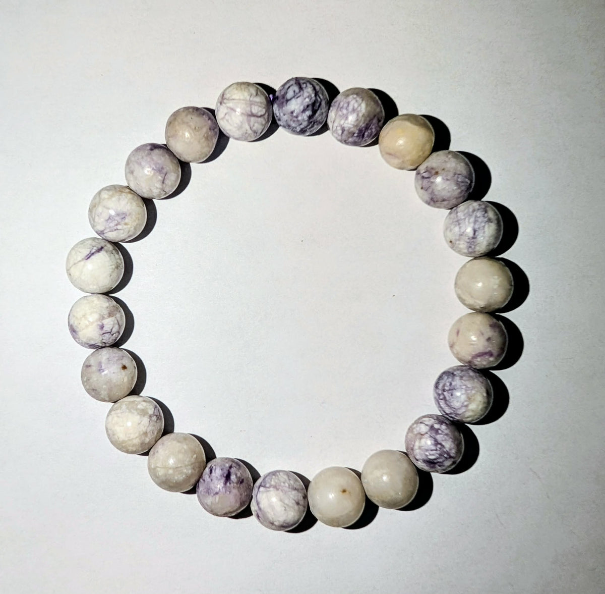 Tiffany Stone genuine gemstone beaded bracelet featuring polished 8mm beads with violet, purple, and creamy white patterns.