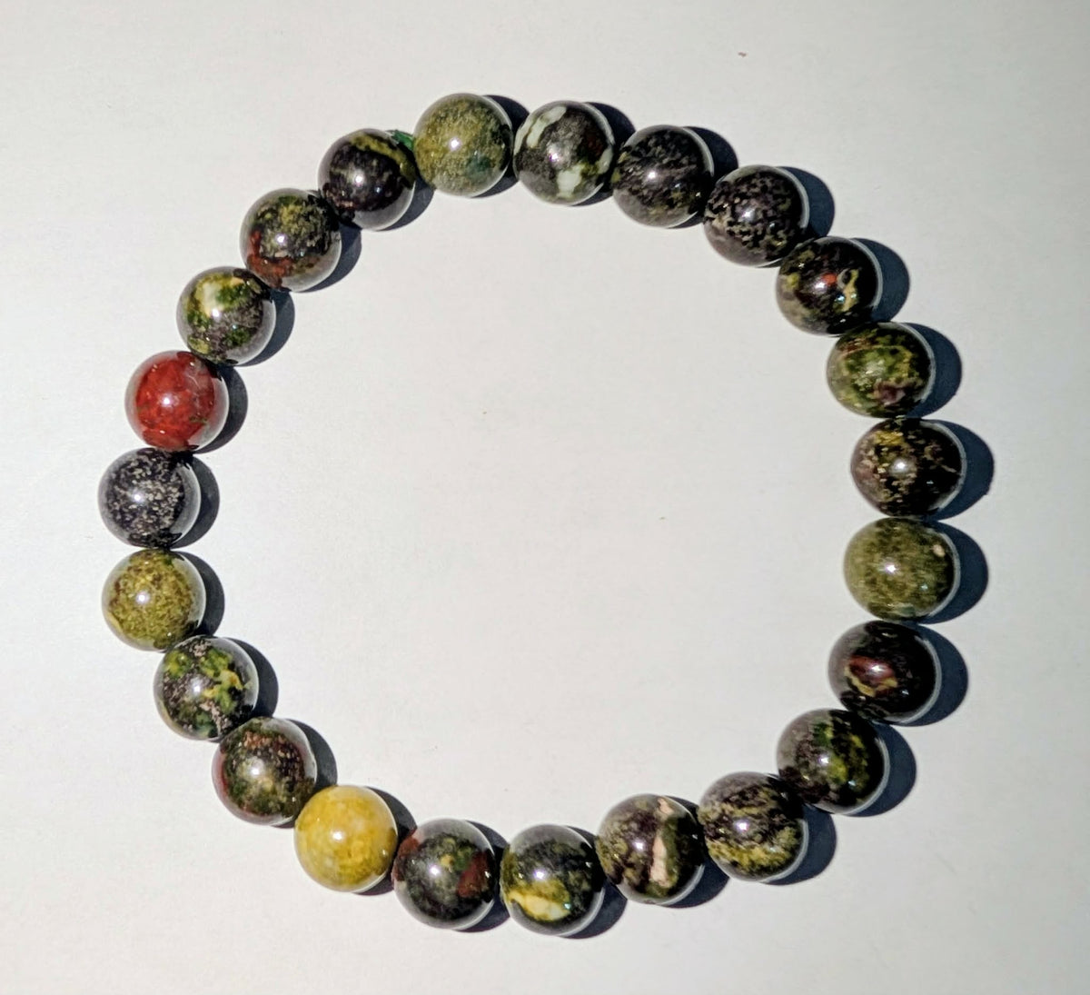 Dragon's Blood genuine gemstone beaded bracelet featuring polished 8mm beads with green tones and distinctive red accents.