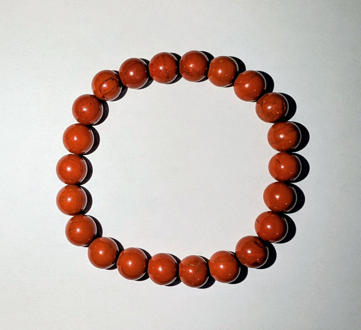 Red Jasper gemstones beaded bracelet with polished 8mm round beads in natural reddish-brown tones.