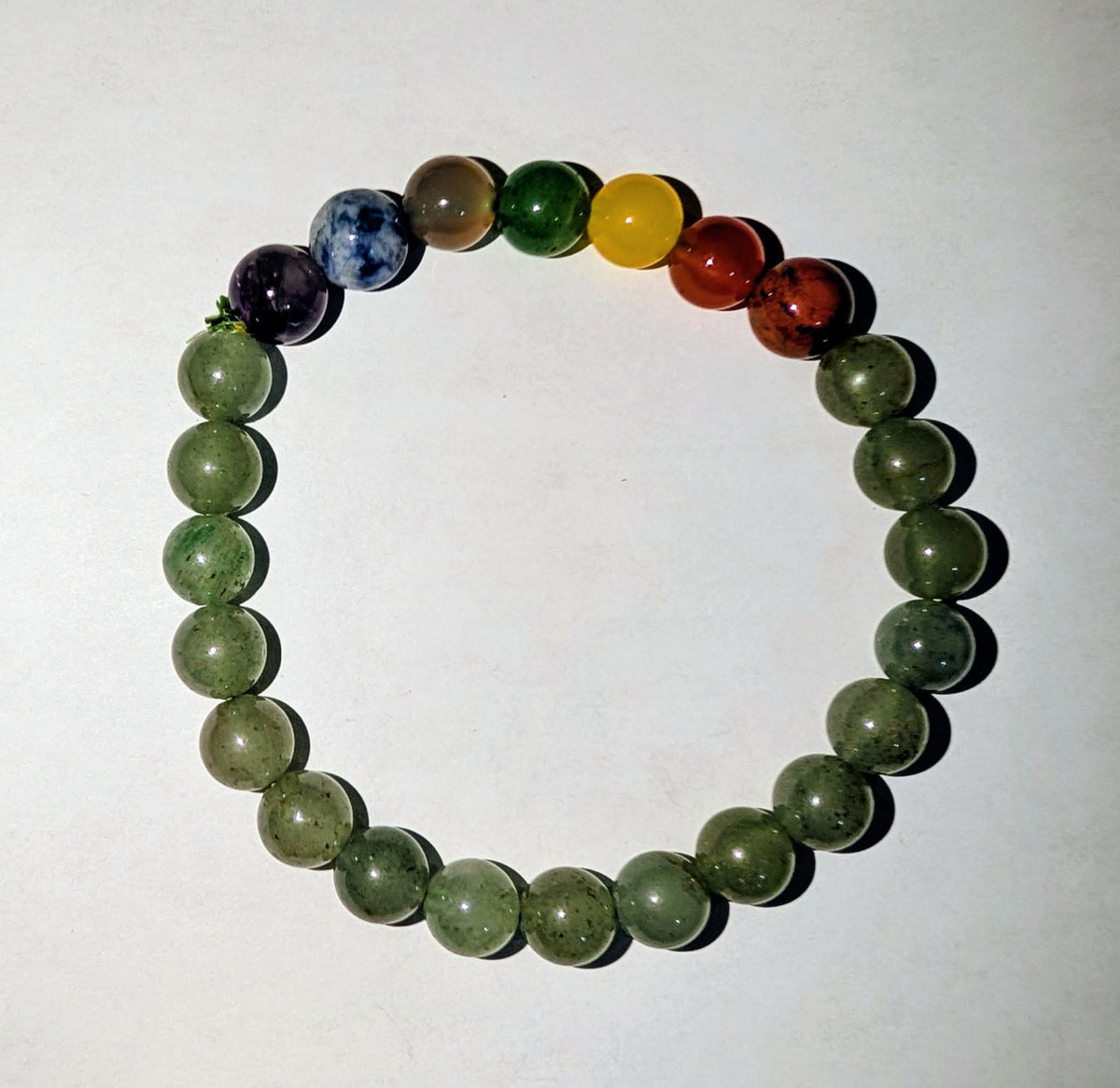 Seven Chakra genuine gemstone beaded bracelet featuring polished 8mm beads in seven vibrant chakra-inspired colors.